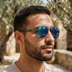Homem usando os óculos de sol Mionelle Carbon Azul Espelhado ao ar livre.