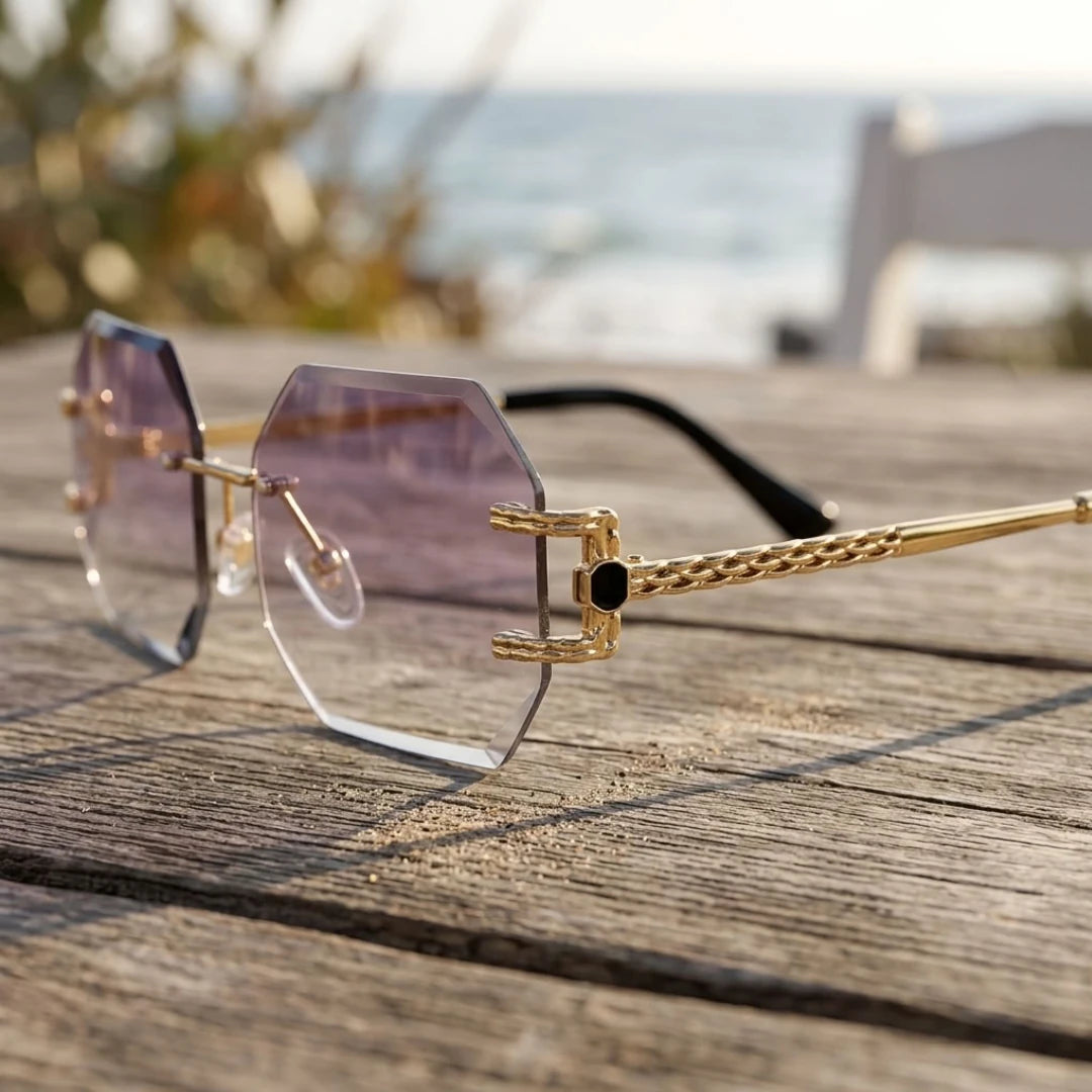 Detalhe dos óculos Mionelle Facet Purple sobre madeira, com lentes lilás e estrutura dourada
