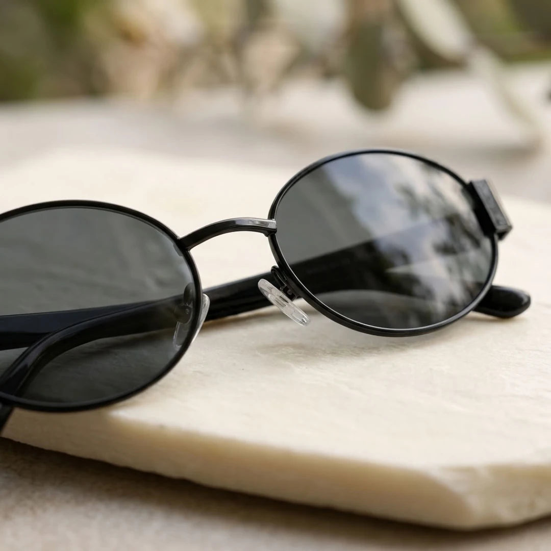 Detalhe das lentes dos óculos Mionelle Selene All Black sobre uma superfície clara