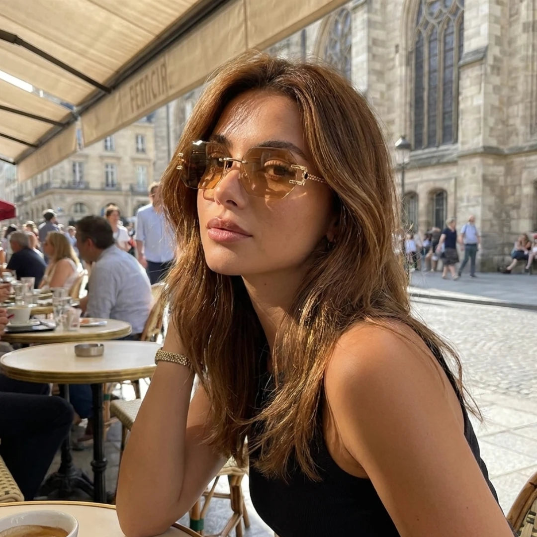 Mulher usando os óculos Mionelle Facet Champagne Gold em um café ao ar livre