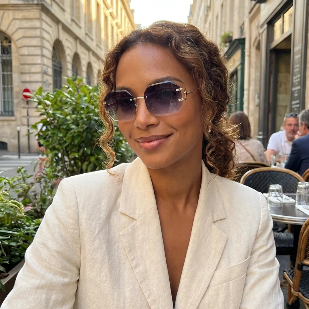 Mulher usando os óculos Mionelle Facet Shadow Black em um café ao ar livre