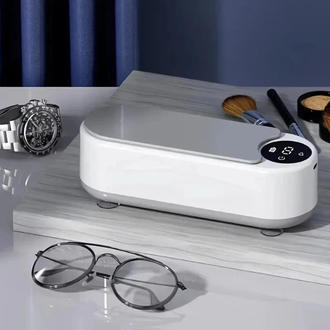 Limpador ultrassônico de óculos Mionelle Clair com tampa cinza sobre uma mesa e um par de óculos à frente.