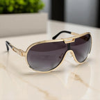 Óculos de Sol Aviador Vintage Masculino e Feminino Mionelle Tesla Golden Preto sobre uma mesa de mármore